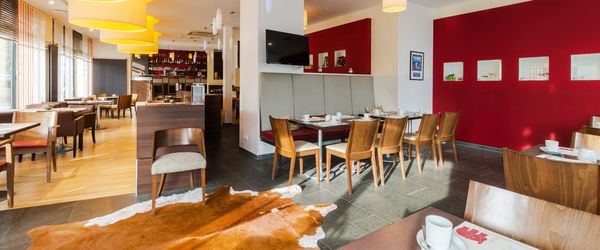 Ein Modern eingerichteter Restaurantbereich des Tagungshotels Esplanade Dortmund mit gedeckten für Frühstück Tischen.