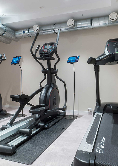 Modern fitness room with a treadmill, cross trainer, and exercise equipment for an effective workout.