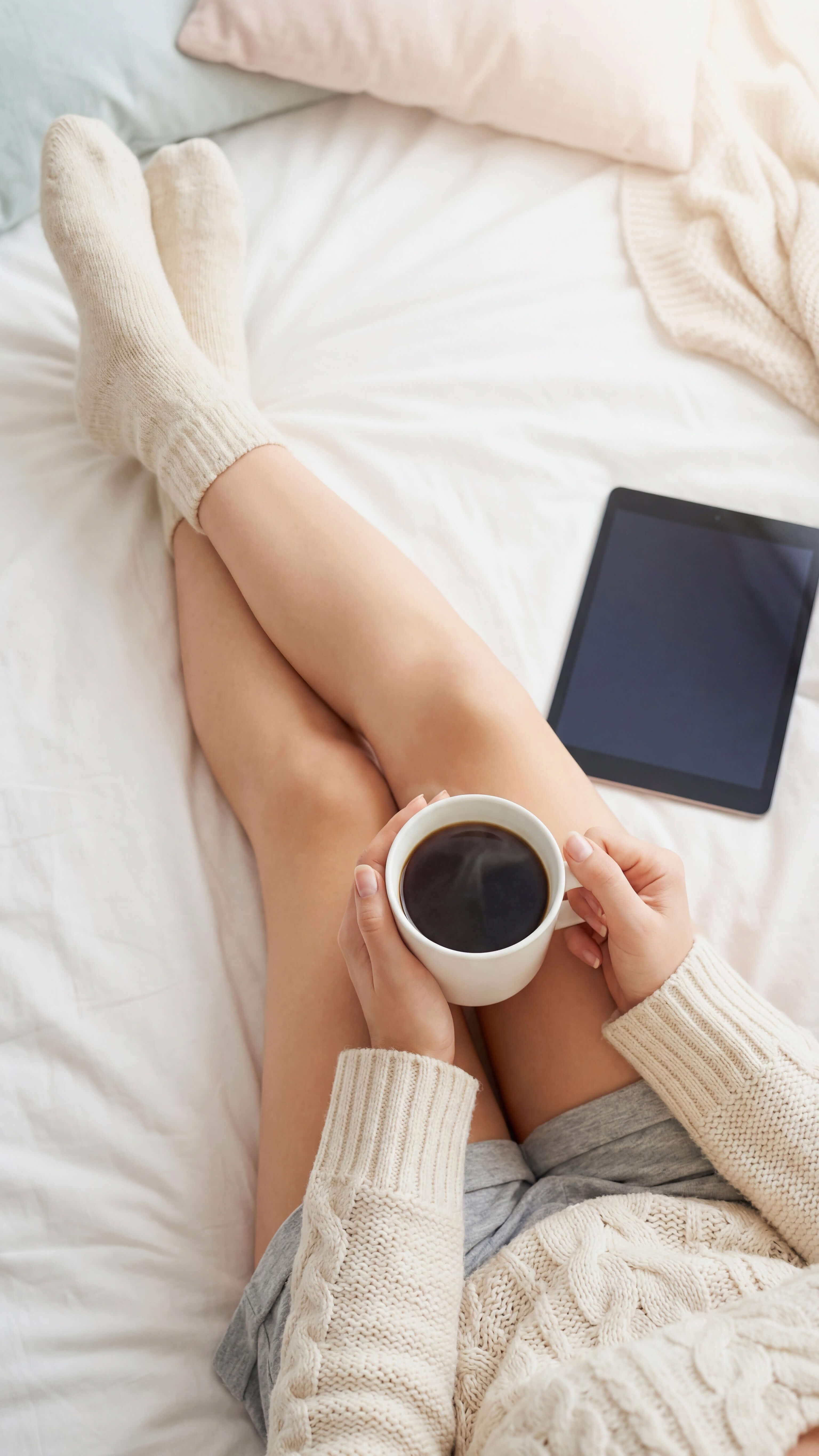 A relaxed morning in bed with coffee and a tablet – perfect for arriving and unwinding.